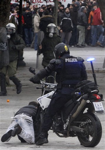 
 ** ALTERNATIVE CROP OF ATH144 ** A policeman on a motorcycle crashes into youth during clashes in Athens, Wednesday, Dec. 15, 2010. Hundreds of protesters clashed with riot police across central Athens Wednesday, smashing cars and hurling gasoline bombs during a massive labor protest against the government's austerity measures. Wednesday's violence occurred after some 20,000 protesters marched to parliament during a general strike against a new round of labor reforms in the crisis-hit country. (AP Photo/Alkis Konstantinidis)
 