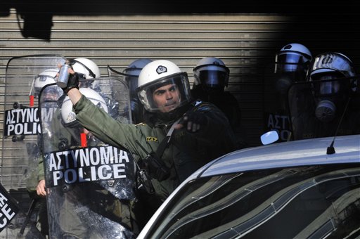 
 A riot police officer throws a flash grenade to protesters during clashes in northern port city of Thessaloniki, Greece, Wednesday, Dec. 15, 2010. Protesters clashed with riot police across Athens on Wednesday, torching cars, hurling gasoline bombs and sending Christmas shoppers fleeing in panic during a general strike against the government's latest austerity measures. (AP Photo/Nikos Giakoumidis)
 