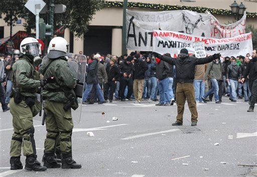 
 A protester taunts police during clashes in Athens,Wednesday, Dec. 15, 2010. Hundreds of protesters clashed with riot police across central Athens, smashing cars and hurling gasoline bombs during a massive labor protest against the government's austerity measures. The violence occurred after some 20,000 protesters marched to parliament during a general strike against a new round of labor reforms in the crisis-hit country. (AP Photo/Thanassis Stavrakis)
 