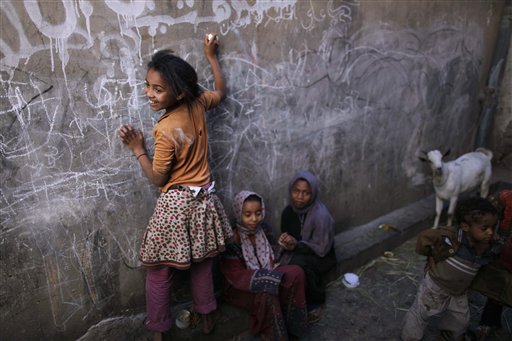 
 In this photo of Friday, Dec. 3, 2010 a Yemeni girl writes on a wall as she and other children play in an alley of the old city of Sanaa, Yemen. More than 50 percent of Yemen's children are malnourished, rivaling war zones like Sudan's Darfur and parts of sub-Saharan Africa. That's just one of many worrying statistics in Yemen. Nearly half the population lives below the poverty line of $2 a day and doesn't have access to proper sanitation. Less than a tenth of the roads are paved. Water is running out. Tens of thousands have been displaced from their homes by conflict, flooding into cities. The government is riddled with corruption, has little control outside the capital, and its main source of income, oil, could run dry in a decade. (AP Photo/Muhammed Muheisen)
 
