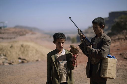 
 In this photo of Thursday, Nov. 11, 2010 Yemeni boys, one holding a hawk and another a hunting riffle, wait to perform to make money on the outskirts of Sanaa, Yemen. More than 50 percent of Yemen's children are malnourished, rivaling war zones like Sudan's Darfur and parts of sub-Saharan Africa. That's just one of many worrying statistics in Yemen. Nearly half the population lives below the poverty line of $2 a day and doesn't have access to proper sanitation. Less than a tenth of the roads are paved. Water is running out. Tens of thousands have been displaced from their homes by conflict, flooding into cities. The government is riddled with corruption, has little control outside the capital, and its main source of income, oil, could run dry in a decade. (AP Photo/Muhammed Muheisen)
 