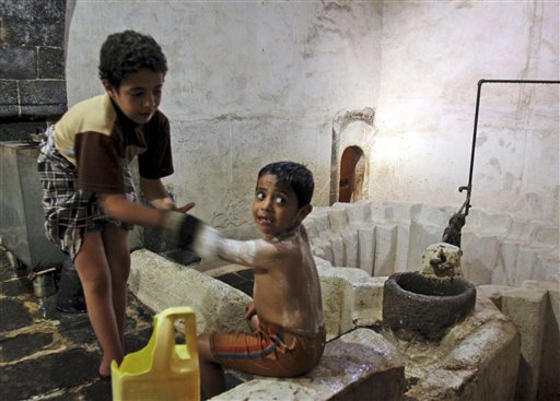 
 In this photo of Friday, Nov. 5, 2010 a Yemeni boy bathes a child in a public bath in Sanaa, Yemen. More than 50 percent of Yemen's children are malnourished, rivaling war zones like Sudan's Darfur and parts of sub-Saharan Africa. That's just one of many worrying statistics in Yemen. Nearly half the population lives below the poverty line of $2 a day and doesn't have access to proper sanitation. Less than a tenth of the roads are paved. Water is running out. Tens of thousands have been displaced from their homes by conflict, flooding into cities. The government is riddled with corruption, has little control outside the capital, and its main source of income, oil, could run dry in a decade. (AP Photo/Hasan Jamali)
 