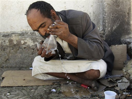 
 In this Friday, Nov. 5, 2010 photo a Yemeni man drinks water from a plastic bag while sitting outside a mosque in Sanaa,Yemen. More than 50 percent of Yemen's children are malnourished, rivaling war zones like Sudan's Darfur and parts of sub-Saharan Africa. That's just one of many worrying statistics in Yemen. Nearly half the population lives below the poverty line of $2 a day and doesn't have access to proper sanitation. Less than a tenth of the roads are paved. Water is running out. Tens of thousands have been displaced from their homes by conflict, flooding into cities. The government is riddled with corruption, has little control outside the capital, and its main source of income, oil, could run dry in a decade. (AP Photo/Hasan Jamali)
 