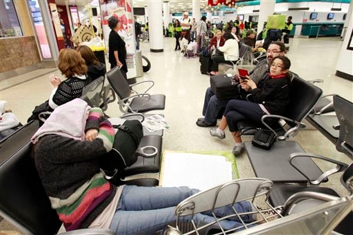 
 Candela Gonzalez, foreground, of Argentina, sleeps at Miami International Airport in Miami, Thursday, Dec. 23, 2010 as she waits for her flight to London where she will spend the holidays. (AP Photo/Alan Diaz)
 