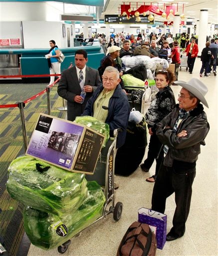 
 Passengers wait in line to check in as they prepare to travel to Cuba at Miami International Airport in Miami, Thursday, Dec. 23, 2010. (AP Photo/Alan Diaz)
 