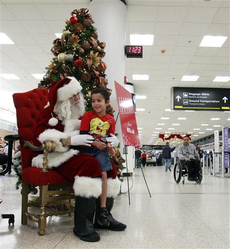 
 Mark Anthony Sepulveda, 6-years-old, of Hialeah, Fla., tells Santa his wishes for Christmas at Miami International Airport in Miami, Thursday, Dec. 23, 2010. (AP Photo/Alan Diaz)
 