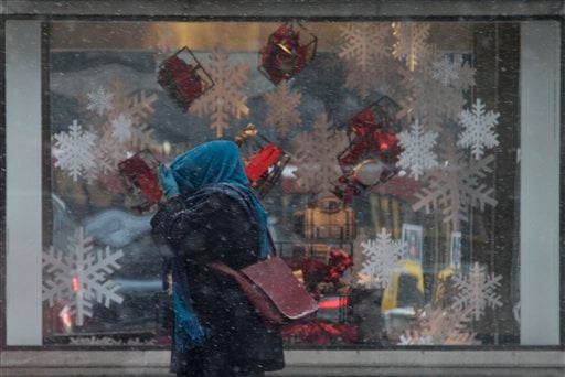 
 A woman covers her head with her scarf as she walks on the Michigan avenue in the snow in Chicago, Friday, Dec. 24, 2010. Light snow started falling this morning in Chicago and was expected to continue through the afternoon before tapering off this evening. (AP Photo/Nam Y. Huh)
 