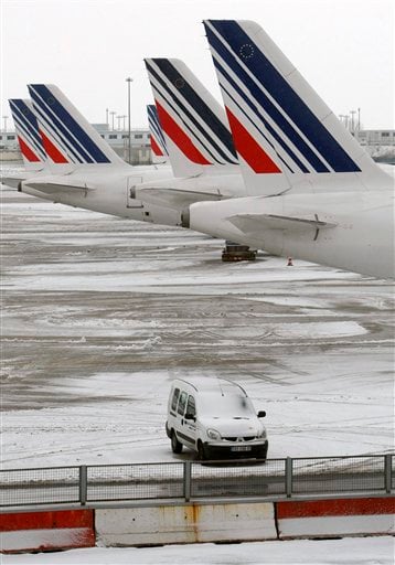 
 Planes are seen on the snow covered tarmac at the Charles-de-Gaulle Roissy airport, near Paris, Friday Dec. 24, 2010. The civil aviation authority asked Paris' Charles de Gaulle airport to cancel 20 percent of flights because of snow. (AP Photo/Jacques Brinon)
 
