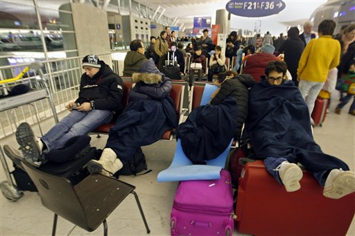 
 Passengers wait for their flights in a terminal after sleeping a night at the Charles-de-Gaulle Roissy airport, near Paris, Friday Dec. 24, 2010. The civil aviation authority asked Paris' Charles de Gaulle airport to cancel 20 percent of flights because of snow. (AP Photo/Jacques Brinon)
 