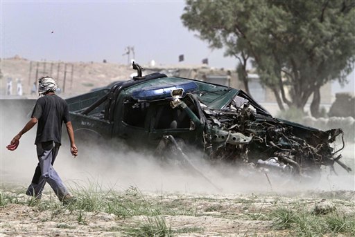 
 A man walks near the wreckage of a police vehicle at the site where an improvised explosive device (IED) detonated, wounding several police officers in Jalalabad, east of Kabul, Afghanistan on Tuesday, Aug. 24, 2010. (AP Photo/Rahmat Gul)
 