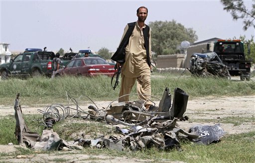 
 A police officer in civilian clothes looks at part of the wreckage of a police vehicle at the site where an improvised explosive device (IED) detonated, wounding several police officers in Jalalabad, east of Kabul, Afghanistan on Tuesday, Aug. 24, 2010. (AP Photo/Rahmat Gul)
 