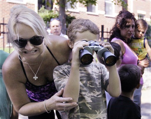
 Donna Berry, 43, cringes and her son Caleb, 8, uses binoculars to look at a 3 1/2-4 foot American Alligator that was swimming in the North branch of the Chicago River, Monday, Aug. 23, 2010, in Chicago. The alligator is the second to be sighted in the area this month. On Aug. 6, 2010 a 2 1/2 foot alligator was captured nearby. (AP Photo/M. Spencer Green)
 