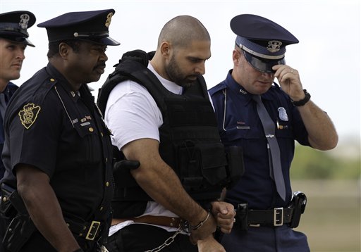 
 Elias Abuelazam is escorted by authorities after arriving on a flight in Flint, Mich., Thursday, Aug. 26, 2010. Abuelazam had been held in an Atlanta jail since his Aug. 11 arrest at the city's airport. He waived extradition Aug. 13, and officials had 15 days to bring him to Michigan. The 33-year-old is charged with assault with intent to commit murder in the July 27 stabbing of a 26-year-old Flint man. It's one of 14 stabbings, of men in the Flint area, about 70 miles northwest of Detroit. He's also suspected in similar stabbings in Virginia and Ohio.(AP Photo/Paul Sancya, Pool)
 