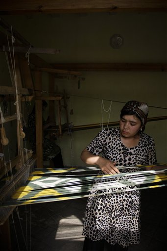 
 In this May 18, 2010 photo, a woman weaves silk fabric in a workshop in Margilan, Uzbekistan. The silkworm business dates back centuries to the Silk Road that ran through this Central Asian country. But its modern-day incarnation as a state monopoly has a dark side. Farmers say they are threatened with fines or loss of their land leases for missing quotas, and that these are so high that they have no choice but to draft their children into the work. (AP Photo)
 