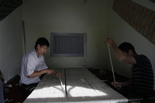 
 In this May 18, 2010 photo, men reel silk fiber in a workshop in Margilan, Uzbekistan. The silkworm business dates back centuries to the Silk Road that ran through this Central Asian country. But its modern-day incarnation as a state monopoly has a dark side. Farmers say they are threatened with fines or loss of their land leases for missing quotas, and that these are so high that they have no choice but to draft their children into the work. (AP Photo)
 