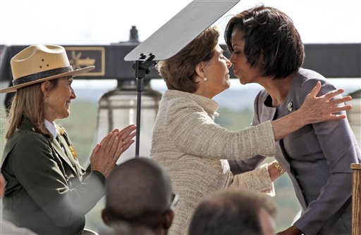 
 First lady Michelle Obama, right, is embraced by former first lady Laura Bush, center, after making remarks during a commemorative service at the temporary Flight 93 memorial in Shanksville, Pa., Saturday, Sept. 11, 2010. At left is Joanne M. Hanley, superintendent of the Flight 93 National Memorial. (AP Photo/Gene J. Puskar)
 