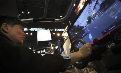 
 A visitor tries out 'Gran Tourismo 5,' Sony's new racing simulator game for its PlayStation 3 at the Tokyo Game Show in Makuhari, near Tokyo, Thursday, Sept. 16, 2010. Sony's PlayStation 3 game console will work as a Blu-ray disc player for 3-D movies and music videos, not just 3-D games, with a software update download starting Sept. 21.(AP Photo/Junji Kurokawa)
 