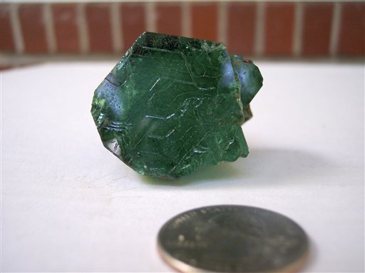 
 This Aug 17, 2009 photo provided by Terry Ledford shows the Carolina Emperor emerald prior to cutting, with a U.S. 25-cent coin in the foreground. Gem experts say an emerald yielded at a North Carolina farm may be the biggest ever uncovered in North America. The 65-carat emerald nicknamed the Carolina Emperor was pulled from a farm in the rural community of Hiddenite, about 50 miles (80 kilometers) northwest of Charlotte. (AP Photo/Courtesy Terry Ledford) NO SALES
 