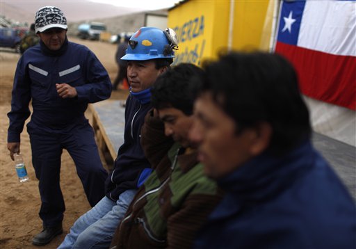 
 Workers of the San Jose mine sit at the camp where relatives of 33 trapped miners wait outside the collapsed mine in Copiapo, Chile, Tuesday Aug. 31, 2010. Thirty-three men stuck far underground are now the longest-trapped miners in recent history as a huge drill begins digging a planned escape route. The miners have been trapped since Aug. 5. (AP Photo/Roberto Candia)
 