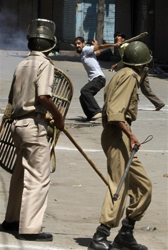 
 Kashmiri protesters throw stones at Indian policemen after police fire at a group of people playing carom board on a street during a curfew hours, in Srinagar, India, Monday, Aug. 30, 2010. (AP Photo/Mukhtar Khan)
 