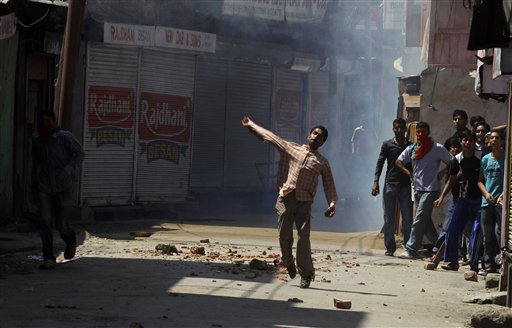 
 Kashmiri protesters throw stones at Indian policemen after police fire at a group of people playing carom board on a street during a curfew in Srinagar, India, Monday, Aug. 30, 2010. (AP Photo/Mukhtar Khan)
 