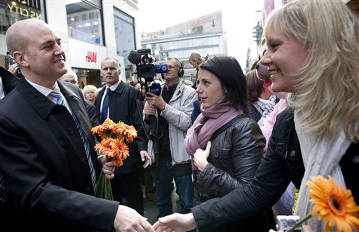 
 Sweden's Prime Minister Fredrik Reinfeldt presents flowers to voters during general elections in Stockholm, Sweden Sunday Sept. 19, 2010. Voting started Sunday in Sweden's election with polls showing the center-right government heading for a historic second term, but an Islam-bashing far-right group could spoil its majority. (AP Photo/Pontus Lundahl)
 