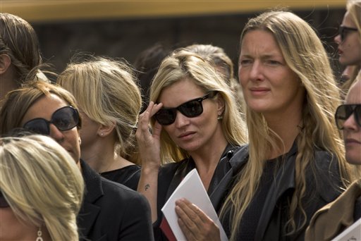 
 British model Kate Moss, centre, adjust her sunglasses as she listens to Scottish bagpipers playing outside the memorial service for Alexander McQueen at St Paul's Cathedral in London, which takes place during London Fashion Week, in London, Monday, Sept. 20, 2010. (AP Photo/Joel Ryan)
 
