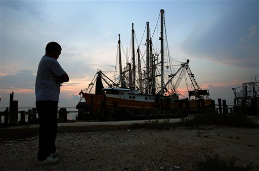 
 FILE - In this June 21, 2010 file photo, a fisherman stands near commercial fishing boats in a marina at sunset in Grand Isle, La. Retired Coast Guard Adm. Thad Allen, the federal government's point man on the disaster, said Sunday, Sept. 19, 2010, BP's well 'is effectively dead.' A permanent cement plug sealed BP's well nearly 2.5 miles below the sea floor in the Gulf of Mexico, five agonizing months after an explosion sank a drilling rig and led to the worst offshore oil spill in U.S. history. (AP Photo/Patrick Semansky, File)
 