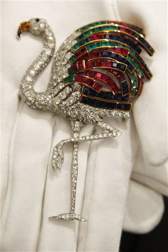 
 A Sotheby's employee holds a 1940 ruby, sapphire, emerald, citrine and diamond clip on display at the auction house in London, Thursday, Sept. 23, 2010. The clip, formerly in the collection of the Duchess of Windsor, and created by Jeanne Toussaint for Cartier is to be auctioned in 'The Jewels of the Duchess of Windsor' sale on Nov. 30 with an estimated price of 1,000,000 to 1,500,000 pounds (US$1,566,416 to 2,349,624 or euros1,175,595 to 1,763,392). (AP Photo/Sang Tan)
 