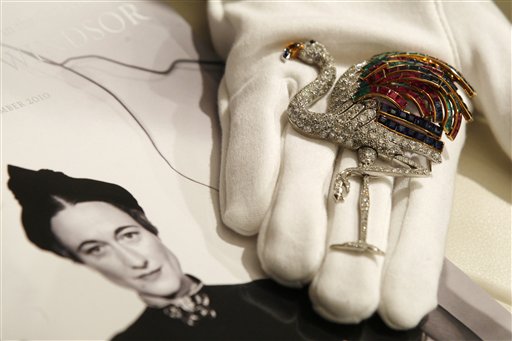 
 A Sotheby's employee poses with a 1940 ruby, sapphire, emerald, citrine and diamond clip on display at the auction house in London, Thursday, Sept. 23, 2010. The clip, formerly in the collection of the Duchess of Windsor, created by Jeanne Toussaint for Cartier is to be auctioned in 'The Jewels of the Duchess of Windsor' sale on Nov. 30 with an estimated price of 1,000,000 to 1,500,000 pounds (US$1,566,416 to 2,349,624 or euros 1,175,595 to 1,763,392). (AP Photo/Sang Tan)
 