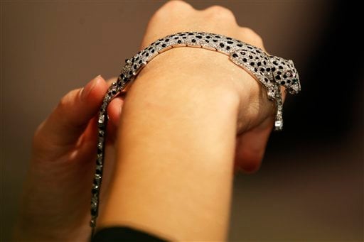 
 A Sotheby's employee pose with a 1952 onyx and diamond panther bracelet on display at the auction house in London, Thursday, Sept. 23, 2010. The bracelet made by Cartier, formerly in the collection of the Duchess of Windsor is to be auctioned in 'The Jewels of the Duchess of Windsor' sale on Nov. 30 with an estimated price of 1,000,000 to 1,500,000 pounds (US$1,566,416 to 2,349,624 or 1,175,595 to 1,763,392 euro). (AP Photo/Sang Tan)
 