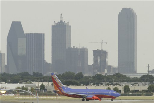 
 FILE - In this July 15, 2005 file photo, downtown Dallas can be seen in the background as a Southwest aircraft taxis along the runway at Love Field in Dallas. Southwest Airlines said Monday, Sept. 27, 2010, it will buy AirTran for about $1.42 billion. The move will put Southwest in head-to-head competition with Delta Air Lines in Delta's home base of Atlanta. (AP Photo/Matt Slocum, file)
 