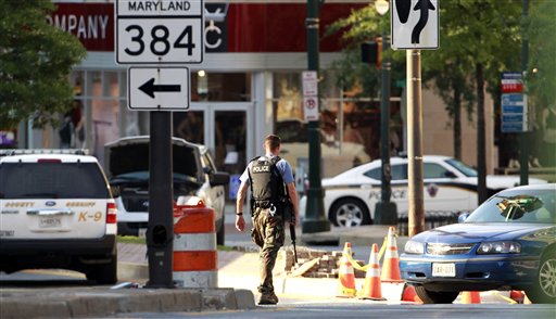
 An armed police officer walks across the street from Discovery Channel network building in Silver Spring, Md., Wednesday, Sept. 1, 2010. Police shot and killed a man upset with the Discovery Channel network's programming who took two employees and a security officer hostage at the company's headquarters Wednesday, officials said. All three hostages escaped safely. (AP Photo/Manuel Balce Ceneta)
 