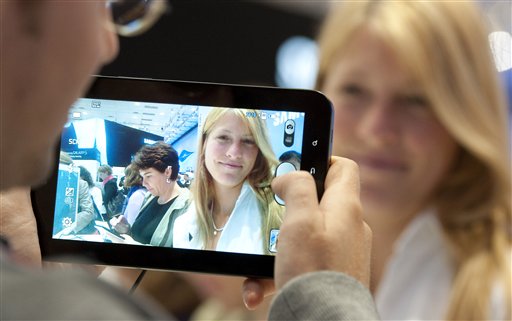 
 A man takes a photograph of a woman with the new Samsung Galaxy Tab, a tablet computer to compete with the Apple iPad at IFA, the world's largest trade fair for consumer electronics and electrical home appliances, in Berlin, Germany, Thursday, Sept. 2, 2010. IFA takes place from Sept. 3 to Sept. 8, 2010 on the Berlin Exhibition Grounds. (AP Photo/Gero Breloer)
 