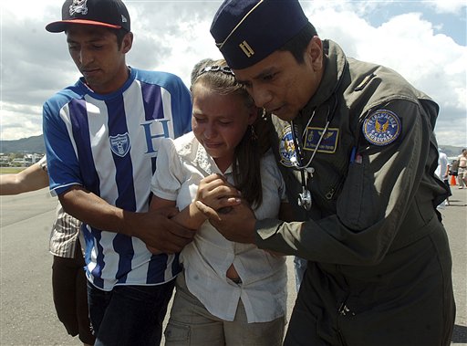 
 An unidentified woman is aided by an Air Force serviceman and an unidentified person at a ceremony that returned the bodies of 16 Hondurans who were killed in Mexico while trying to reach the U.S. border, to family members in Tegucigalpa, Honduras, Wednesday, Sept. 1, 2010. The bodies of 72 Central and South American migrants, who were allegedly killed by a Mexican drug cartel, were found within 100 miles of the U.S. border on Aug. 24. (AP Photo/Fernando Antonio)
 