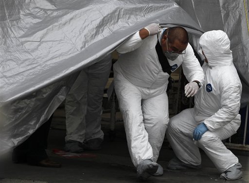 
 A forensic worker leaves the entrance of a funeral home after a truck arrived carrying the bodies of some of the 72 migrants who were killed in northern Mexico while trying to reach the US border, in Mexico City, Wednesday Sept. 1, 2010. One of two survivors told Mexican investigators that the migrants were detained by people who identified themselves as Zetas, a drug gang that dominates parts of the northern state of Tamaulipas and then killed them when they refused to smuggle drugs. (AP Photo/Eduardo Verdugo)
 