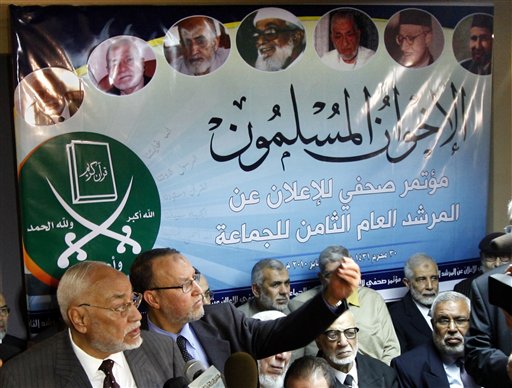
 In this Jan.16, 2010 picture Muslim Brotherhood former supreme guide Mohammed Mahdi Akef, left, and senior member Essam al-Erian second left, gesture during a presser in Cairo Egypt under a billboard showing the group's founder Hassan al-Banna, top right, and its supreme guides. The group, founded in 1928, was banned in 1954 on charges of using violence. But it has since renounced violence, expanded its international presence and participated in Egyptian elections as independents despite frequent crackdowns. Arabic read ' The Muslim Brotherhood'. Others are old group memebrs. (AP Photo/Amr Nabil)
 