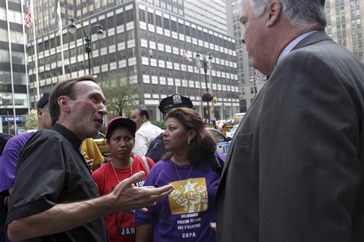 
 In this Sept. 2, 2010 photograph, Rev. Mark Hallinan, left, joins former janitors Martha Escobar, second from left, and Elva Polanco, both from Los Angeles, as they deliver a letter intended for J.P. Morgan Chase CEO Jaime Dimon to Patrick J. Bradley, V.P. Global Security and Investigations J.P. Morgan Chase, during a demonstration to call on Dimon to create jobs, not destroy them, in New York. (AP Photo/Mary Altaffer)
 