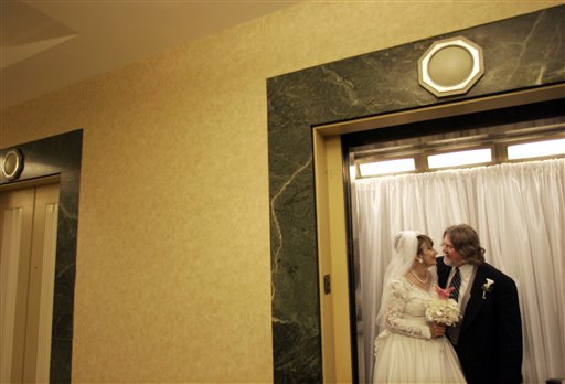 
 FILE - In this Feb. 14, 2007 file photo, Virginia Holder and Garon Cagle, from Lubbock, Texas, prepare to ride the bridal elevator for pictures on the viewing deck of the Empire State Building in New York. Otis Elevator has won a contract to replace all 68 elevators at New York's iconic Empire State Building with faster, more efficient lifts. It is the largest modernization project ever undertaken by the 158-year-old elevator company. (AP Photos/Bebeto Matthews, File)
 