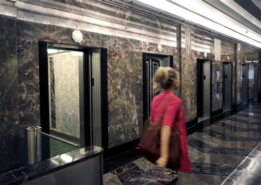 
 A woman walks past a bank of elevators in the Empire State Building in New York, Thursday, June 16, 2011. The Empire State Building and Otis Elevator Co., the nation's best-known elevator manufacturer, were set to announce Thursday a partnership to replace and modernize the building's elevators to bring them into the computer age and reduce passenger wait time. (AP Photo/Seth Wenig)
 