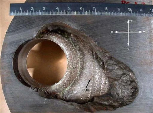 
 This undated photo made available by the Nuclear Regulatory Commission shows a 5-by-5-inch hole in a section cut from the top of the reactor vessel at the Davis-Besse nuclear plant in Ohio. Discovered in February 2002, the hole was eaten by boric acid that spilled from inside the reactor through cracks in the vessel head. Only three-eighths of an inch of steel cladding remained, making a reactor breach likely in as little as two months, by the NRC's estimate. (AP Photo/Nuclear Regulatory Commission)
 