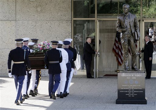 
 A military honor guard carries the casket bearing the body of former first lady Betty Ford as they passes a statue of the former President at Gerald R. Ford Presidential Museum Wednesday, July 13, 2011 in Grand Rapids, Mich. Former first lady will be buried at the museum on Thursday next to her husband former President Gerald R. Ford. (AP Photo/M. Spencer Green)
 