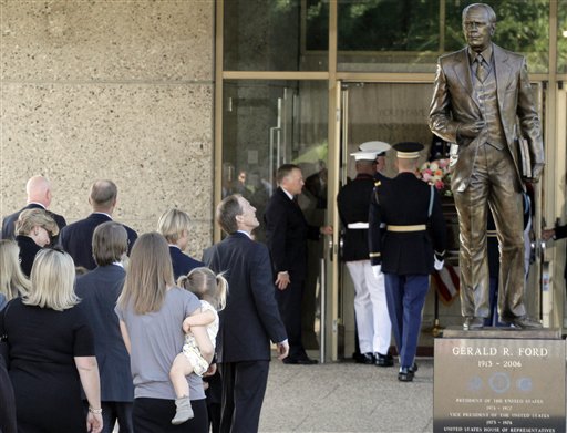 
 Mike Ford looks up at a statue of his father, former President Gerald Ford, as members of the Ford family follow the casket bearing the body of former first lady Betty Ford into the Gerald R. Ford Presidential Museum Wednesday, July 13, 2011, in Grand Rapids, Mich. The former first lady will be buried at the museum on Thursday next to her husband. (AP Photo/M. Spencer Green)
 