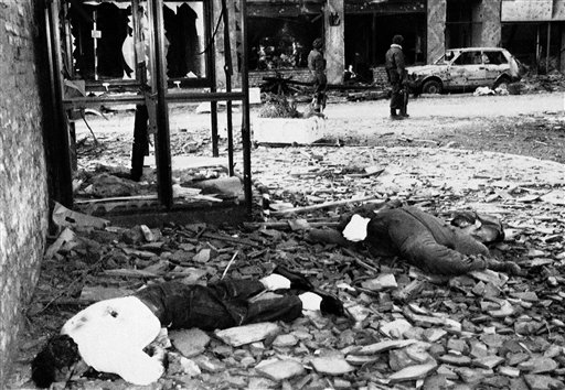 
 FILE - This is a Nov. 21, 1991 file photo of the bodies of civilians lie on a street in Vukovar, Nov. 21, 1991. Goran Hadzic the last fugitive sought by the U.N. Balkan war crimes tribunal was arrested by Serbian authorities Wednesday, July 20, 2011 answering intense international demands for his capture and boosting the country's hopes of becoming a candidate for European Union membership. In the Wars Crimes indictment Hadzic is accused of responsibility for the 1991 leveling of Vukovar, said to be the first European city entirely destroyed since World War II. In one of the worst massacres in the Croatian conflict, Serb forces seized at least 264 non-Serbs from Vukovar Hospital after a three-month siege of the city, took them to a nearby pig farm, tortured, shot and buried them in an unmarked mass grave. (AP Photo/Srdjan Ilic, File)
 