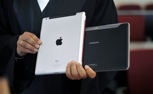 
 FILE - In this Aug. 25, 2011 file photo a lawyer holds an Apple iPad and a Samsung Tablet-PC at a court in Duesseldorf, Germany. A Duesseldorf state court said Friday, Sept. 9, 2011, it would not allow Samsung, based in Seoul, South Korea, to market its Galaxy Tab 10.1 in Germany because it too closely resembles the iPad2. Previously in August the court had ruled in favor of Apple, based in Cupertino, California, forcing Samsung to withdraw its tablet from the market. (AP Photo/dapd, Sascha Schuermann, file)
 