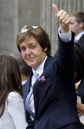
 Former Beatle Paul McCartney gestures as he and American heiress Nancy Shevell leave Marylebone Town Hall, London, after their wedding Sunday, Oct. 9, 2011. McCartney and Shevell were married on Sunday, emerging joyously from a 45-minute civil marriage ceremony to be showered with confetti from fans. (AP Photo/Jonathan Short)
 