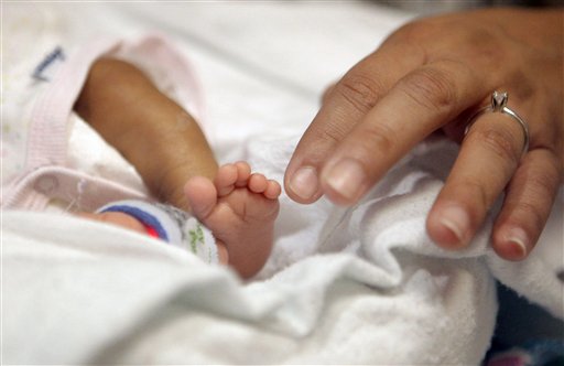 
 Haydee Ibarra, right, touches her 14-week-old daughter, Melinda Star Guido's toes at the Los Angeles County-USC Medical Center in Los Angeles, Wednesday, Dec. 14, 2011. At birth, Melinda Star Guido tipped the scales at only 9 1/2 ounces, a tad less than the weight of two iPhone 4S. Most babies her size don�t survive, but doctors are preparing to send her home as soon as the end of the month. Melinda is believed to be the second smallest baby to survive in the United States and the third smallest in the world. (AP Photo/Jae C. Hong)
 