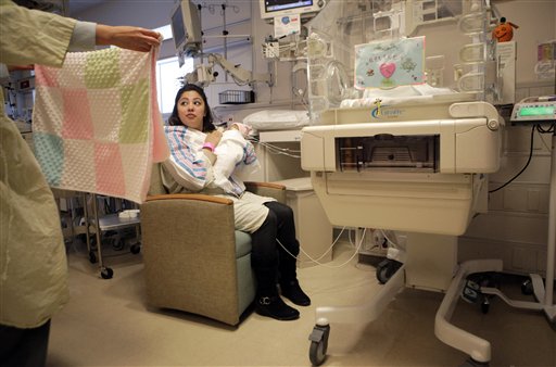 
 A nurse offers Haydee Ibarra a blanket for Ibarra's 14-week-old daughter, Melinda Star Guido, at the Los Angeles County-USC Medical Center in Los Angeles, Wednesday, Dec. 14, 2011. At birth, Melinda Star Guido tipped the scales at only 9 1/2 ounces, a tad less than the weight of two iPhone 4S. Most babies her size don�t survive, but doctors are preparing to send her home as soon as the end of the month. Melinda is believed to be the second smallest baby to survive in the United States and the third smallest in the world. (AP Photo/Jae C. Hong)
 