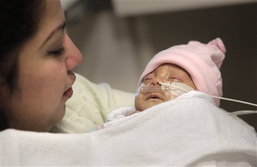 
 Haydee Ibarra, left, holds her 14-week-old daughter, Melinda Star Guido, at the Los Angeles County-USC Medical Center in Los Angeles, Wednesday, Dec. 14, 2011. At birth, Melinda Star Guido tipped the scales at only 9 1/2 ounces, a tad less than the weight of two iPhone 4S. Most babies her size don�t survive, but doctors are preparing to send her home as soon as the end of the month. Melinda is believed to be the second smallest baby to survive in the United States and the third smallest in the world. (AP Photo/Jae C. Hong)
 