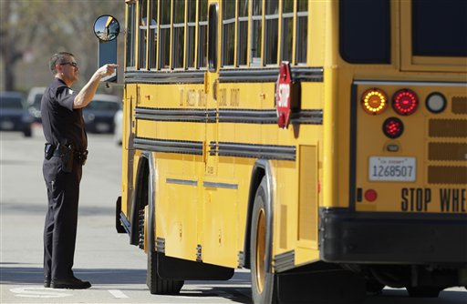 
 A police officer talks to a school bus driver as the bus arrives to pick up students at Gardena High School in Gardena, Calif., Tuesday, Jan. 18, 2011, after reports of a number of students being wounded during a shooting. (AP Photo/Jae C. Hong)
 